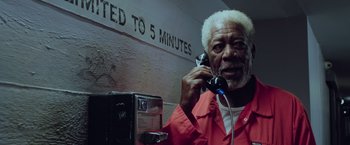 Movie still from “Now You See Me 2” (2016), directed by Jon M. Chu – An older man talking on a phone in front of a wall; Close Up shot, High angle