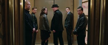 Movie still from “Now You See Me 2” (2016), directed by Jon M. Chu – A group of men standing in front of a elevator; Medium shot, Low angle