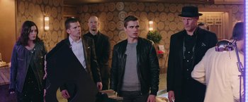 Movie still from “Now You See Me 2” (2016), directed by Jon M. Chu – A group of men standing next to each other in a room; Medium shot, Over the shoulder angle