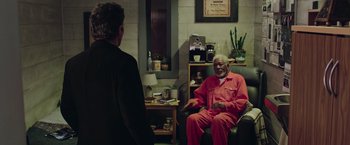 Movie still from “Now You See Me 2” (2016), directed by Jon M. Chu – An older man in a red suit talking to a younger man in a black suit; Wide shot, High angle