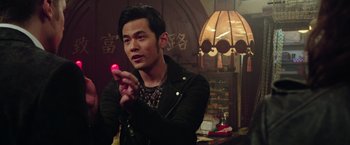 Movie still from “Now You See Me 2” (2016), directed by Jon M. Chu – A man holding a pink object in his hand; Close Up shot, Over the shoulder angle