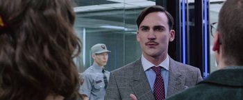 Movie still from “Now You See Me 2” (2016), directed by Jon M. Chu – A man in a suit and tie standing in front of a mirror; Close Up shot, Over the shoulder angle