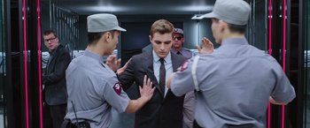 Movie still from “Now You See Me 2” (2016), directed by Jon M. Chu – A group of security guards surrounding a man in a suit; Medium shot, Over the shoulder angle