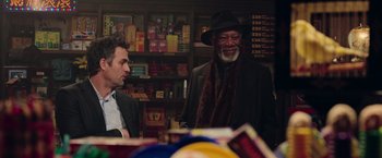 Movie still from “Now You See Me 2” (2016), directed by Jon M. Chu – A man in a suit and a hat standing next to another man in a suit; Medium shot, Over the shoulder angle