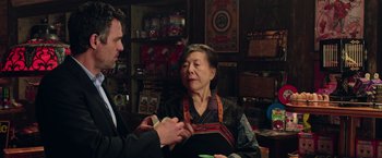 Movie still from “Now You See Me 2” (2016), directed by Jon M. Chu – An older woman wearing an oriental dress talking to a man; Medium shot, Over the shoulder angle