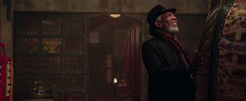 Movie still from “Now You See Me 2” (2016), directed by Jon M. Chu – An older man wearing a black hat and a black coat; Medium shot, Low angle