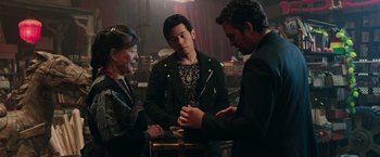 Movie still from “Now You See Me 2” (2016), directed by Jon M. Chu – A group of people standing next to each other in a room; Medium shot, Over the shoulder angle