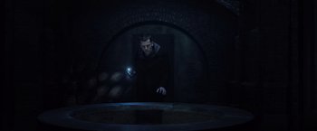 Movie still from “Now You See Me 2” (2016), directed by Jon M. Chu – A man in a dark room looking into a window; Wide shot, High angle