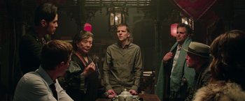 Movie still from “Now You See Me 2” (2016), directed by Jon M. Chu – A group of people standing around a table; Medium shot, Over the shoulder angle