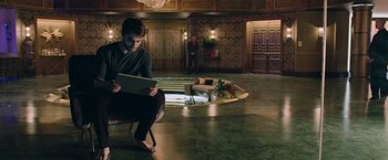 Movie still from “Now You See Me 2” (2016), directed by Jon M. Chu – A man sitting on a chair using a laptop; Wide shot, High angle