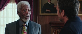 Movie still from “Now You See Me 2” (2016), directed by Jon M. Chu – An older man wearing a suit and tie talking to another man; Close Up shot, Over the shoulder angle