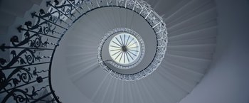 Movie still from “Now You See Me 2” (2016), directed by Jon M. Chu – Looking up at a spiral staircase in a building; Extreme Wide shot, Low angle