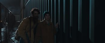 Movie still from “Nowhere” (2023), directed by Albert Pintó – A man and a woman standing next to each other; Medium shot, Low angle