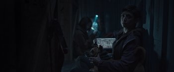 Movie still from “Nowhere” (2023), directed by Albert Pintó – A woman sitting on the ground with a dog in her lap; Medium shot, Over the shoulder angle