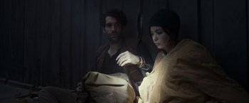 Movie still from “Nowhere” (2023), directed by Albert Pintó – A man and a woman looking at something in a mirror; Medium shot, High angle