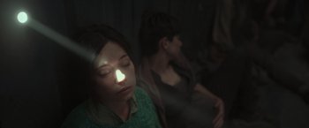 Movie still from “Nowhere” (2023), directed by Albert Pintó – Two people sitting in a dark room with their eyes closed; Close Up shot, High angle