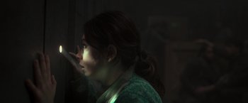 Movie still from “Nowhere” (2023), directed by Albert Pintó – A woman with her hand to her face in a dark room; Close Up shot, Over the shoulder angle