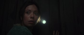 Movie still from “Nowhere” (2023), directed by Albert Pintó – A woman is looking at the camera through a flashlight; Close Up shot, Low angle