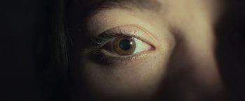 Movie still from “Nowhere” (2023), directed by Albert Pintó – A person's brown eye; Extreme Close Up shot, Overhead angle