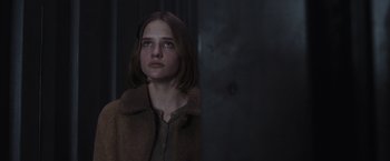 Movie still from “Nowhere” (2023), directed by Albert Pintó – A young girl is standing in front of a wall; Close Up shot, Over the shoulder angle