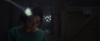 Movie still from “Nowhere” (2023), directed by Albert Pintó – A woman with bruises on her face is looking down; Close Up shot, Low angle