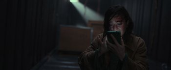 Movie still from “Nowhere” (2023), directed by Albert Pintó – A woman holding a cell phone up to her face; Close Up shot, High angle