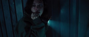 Movie still from “Nowhere” (2023), directed by Albert Pintó – A woman holding a flashlight in a dark room; Close Up shot, High angle
