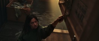 Movie still from “Nowhere” (2023), directed by Albert Pintó – A woman in a green jacket holding onto a wooden object; Medium shot, Low angle