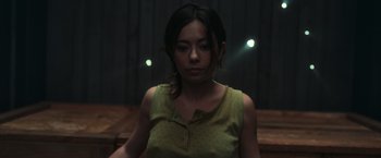 Movie still from “Nowhere” (2023), directed by Albert Pintó – A woman in a green shirt is looking at the camera; Medium shot, Low angle