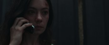 Movie still from “Nowhere” (2023), directed by Albert Pintó – A woman with a knife in her mouth in a dark room; Close Up shot, Low angle