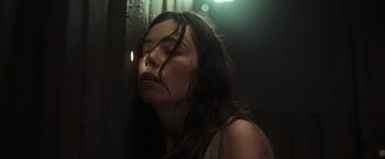 Movie still from “Nowhere” (2023), directed by Albert Pintó – A woman with her eyes closed in a dark room; Close Up shot, Low angle