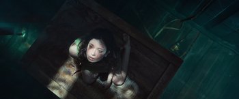 Movie still from “Nowhere” (2023), directed by Albert Pintó – A woman sitting on the ground in a room; Medium shot, Overhead angle