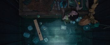 Movie still from “Nowhere” (2023), directed by Albert Pintó – A woman sitting on the floor of a room with boxes; Wide shot, Overhead angle