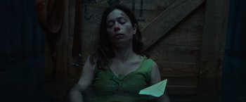 Movie still from “Nowhere” (2023), directed by Albert Pintó – A woman with a paper plane on her chest; Close Up shot, High angle