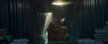 Movie still from “Nowhere” (2023), directed by Albert Pintó – A woman sitting on top of a wooden crate; Extreme Wide shot, Low angle