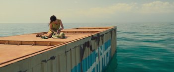 Movie still from “Nowhere” (2023), directed by Albert Pintó – A woman sitting on the side of a boat in the ocean; Extreme Wide shot, High angle