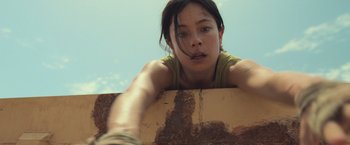 Movie still from “Nowhere” (2023), directed by Albert Pintó – A woman leaning on a wall with a skateboard in front of her face; Close Up shot, Low angle