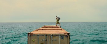 Movie still from “Nowhere” (2023), directed by Albert Pintó – A man standing on the side of a boat in the ocean; Extreme Wide shot, High angle