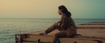 Movie still from “Nowhere” (2023), directed by Albert Pintó – A woman sitting on the edge of a boat looking out at the ocean; Medium shot, Low angle
