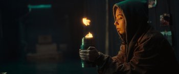 Movie still from “Nowhere” (2023), directed by Albert Pintó – A woman holding a thermos with a flame in it; Close Up shot, Low angle