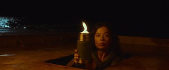 Movie still from “Nowhere” (2023), directed by Albert Pintó – A woman is holding a lit candle in a thermos; Close Up shot, High angle
