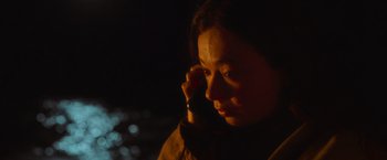 Movie still from “Nowhere” (2023), directed by Albert Pintó – A woman holding a cell phone up to her ear; Close Up shot, High angle