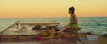Movie still from “Nowhere” (2023), directed by Albert Pintó – A woman sitting on a dock next to a body of water; Wide shot, High angle