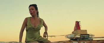 Movie still from “Nowhere” (2023), directed by Albert Pintó – A woman sitting on top of a pile of rocks; Medium shot, Low angle