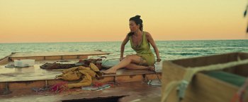 Movie still from “Nowhere” (2023), directed by Albert Pintó – A woman sitting on the back end of a boat; Wide shot, High angle