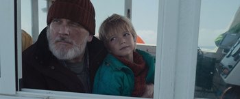 Movie still from “Nowhere” (2023), directed by Albert Pintó – An older man and a young boy looking out a window; Close Up shot, Low angle