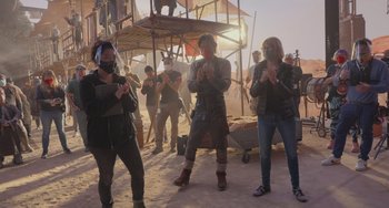 Movie still from “Obi-Wan Kenobi: A Jedi's Return” (2022), directed by David Gelb – A group of people standing in the sand; Wide shot, Low angle