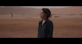 Movie still from “Obi-Wan Kenobi: A Jedi's Return” (2022), directed by David Gelb – A woman standing in the middle of an empty field; Medium shot, Over the shoulder angle
