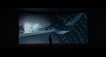 Movie still from “Obi-Wan Kenobi: A Jedi's Return” (2022), directed by David Gelb – A man standing in front of a projection screen; Extreme Wide shot, Low angle