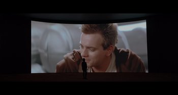 Movie still from “Obi-Wan Kenobi: A Jedi's Return” (2022), directed by David Gelb – A man standing in front of a large screen; Wide shot, Over the shoulder angle